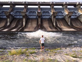 Man standing in front of dam