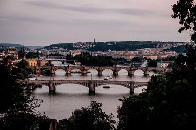 Bridge over river in city against sky