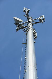 Low angle view of crane against clear blue sky