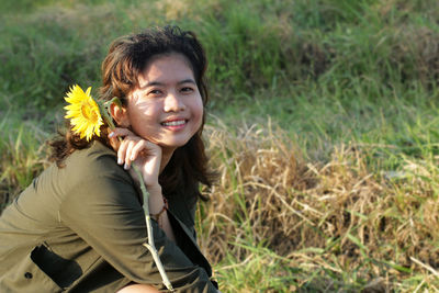Portrait of a smiling young woman sitting on land