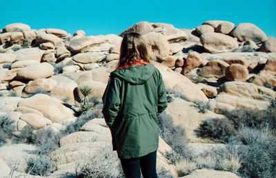 Rear view of man standing on rock