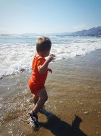 Rear view of boy on beach