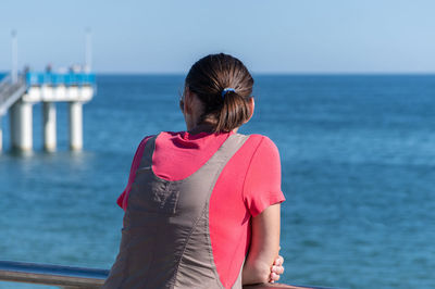 Rear view of woman looking at sea against sky