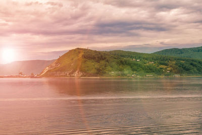 Scenic view of lake by mountains against sky