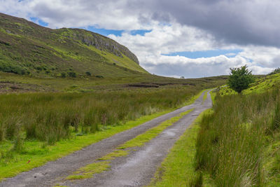 Scenic view of road amidst land against sky