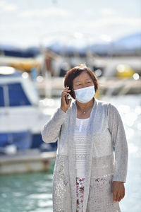 Man wearing sunglasses standing against sea