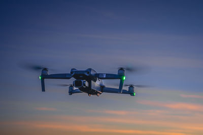 Low angle view of airplane flying against sky during sunset