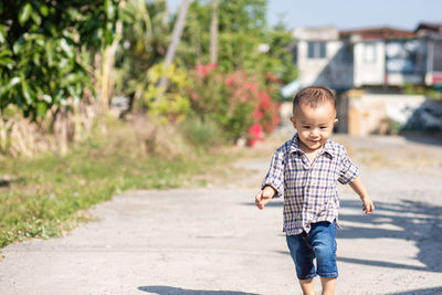 Full length of cute boy running on road