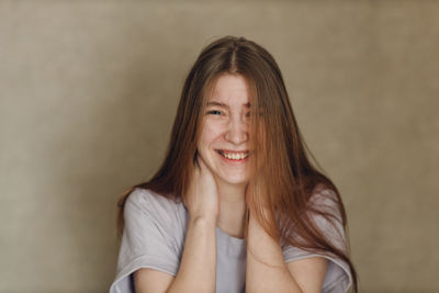 Portrait of young woman against wall