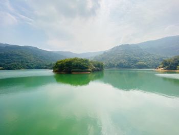 Scenic view of lake and mountains against sky