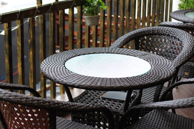 Close-up of empty chairs and table at sidewalk cafe