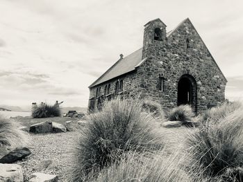 Abandoned building on field against sky