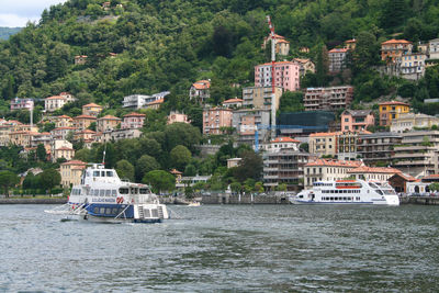 Sailboats in sea by buildings in city