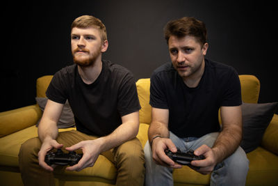 Young man using mobile phone while sitting on sofa