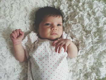 Cute baby girl lying on bed