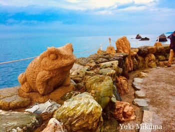 Rocks on beach against sky
