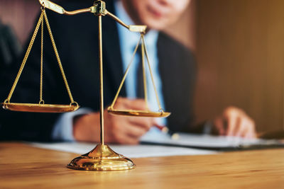 Midsection of lawyer working by weight scale on table