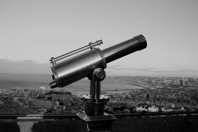 Close-up of coin-operated binoculars against cityscape