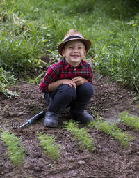 Portrait of boy sitting on field