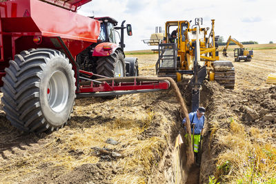 Machine filling ditch in field