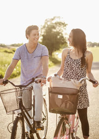 Happy young couple with bicycles standing on country road