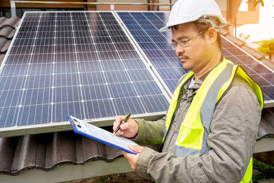 Rear view of man sitting on solar panel