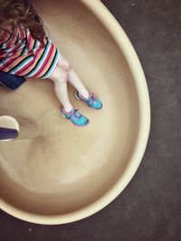 Low section of girl sliding on slide in park