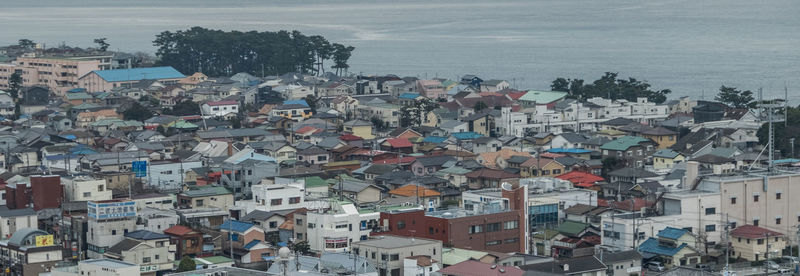 Aerial view of cityscape by sea against sky