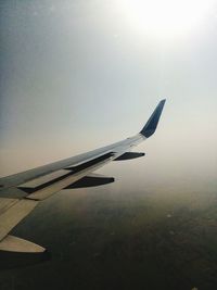 Close-up of airplane wing against sky