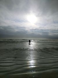 Silhouette person on beach against sky