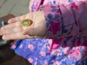 Close-up of woman holding coin