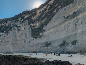 Group of people on rock against the sky