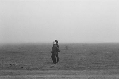 Full length of man standing on field against sky