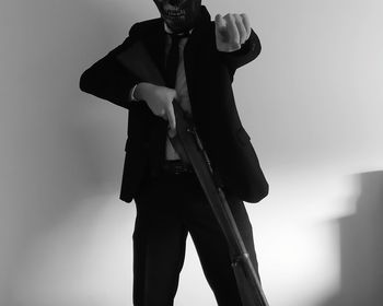 Low angle view of man holding camera against white background