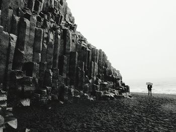 Man standing on cliff against clear sky