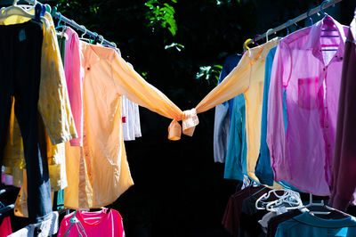 Colorful wet clothes hanging on the steel clothesline for drying by the heat of sun.