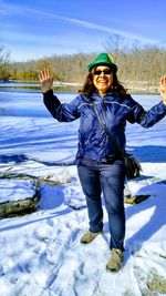 Portrait of a smiling young man standing in snow