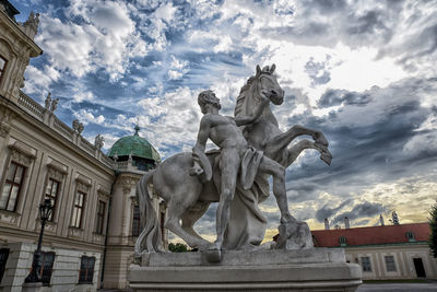 Low angle view of statues on building against sky