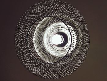 Low angle view of illuminated electric lamp against black background