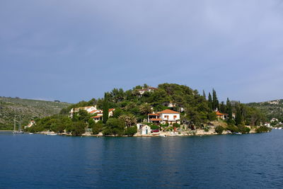 Houses by sea against sky