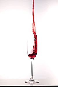 Close-up of red wine on white background