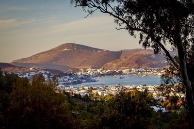 Scenic view of town by sea against sky