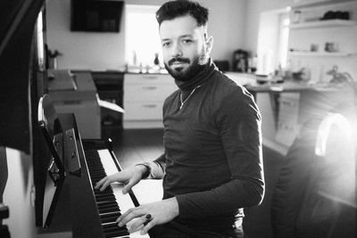 Portrait of man playing piano at home