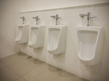 Urinals by wall in bathroom