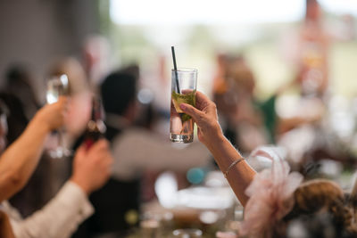 Cropped hand of woman drinking glass