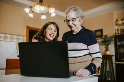 Granddaughter teaching her grandmother something on the laptop