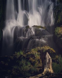 Waterfall falling from mountain in forest