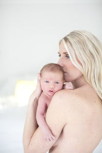 Woman hugging newborn daughter