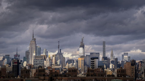 Buildings in city against cloudy sky