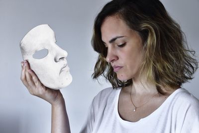 Portrait of young woman against gray background